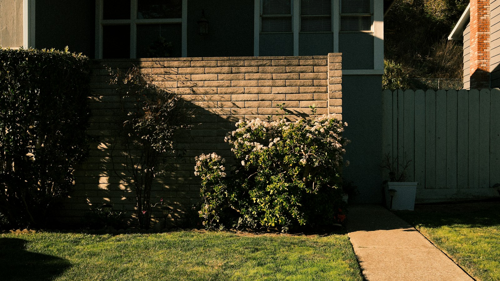 Illustrative photo of a brick suburban house with a walkway and green lawn